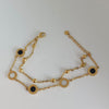 Gold bracelet with black stones on a white background