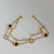 Gold bracelet with black stones on a white background